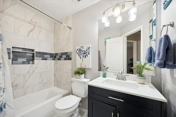 a bathroom with a sink a toilet a mirror a bathtub and shower