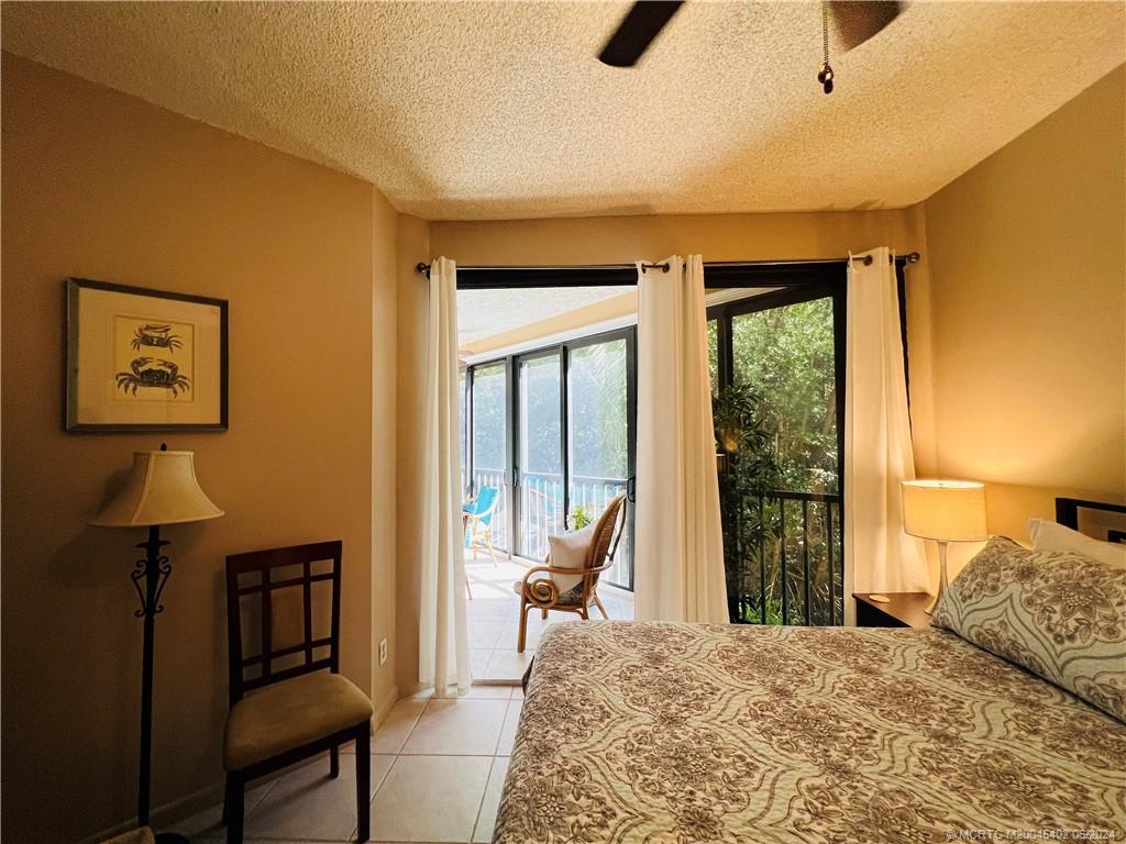 221 Northeast Plantation Road, Unit 215 Stuart, FL 34996 - Photo 33 of 83 a bedroom with a bed and wooden floor