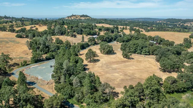 an aerial view of mountain with residential house and lake view