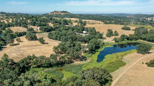 an aerial view of lake residential house with outdoor space and trees around