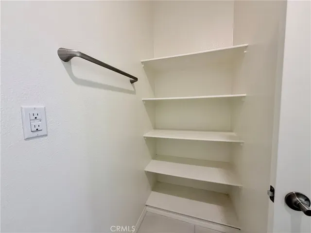 a view of walk in closet with empty racks