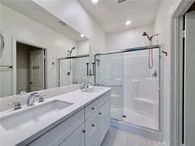 a bathroom with a double vanity sink mirror double shower and a
