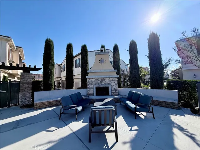 a living room with furniture a fireplace and potted plants with wooden floor
