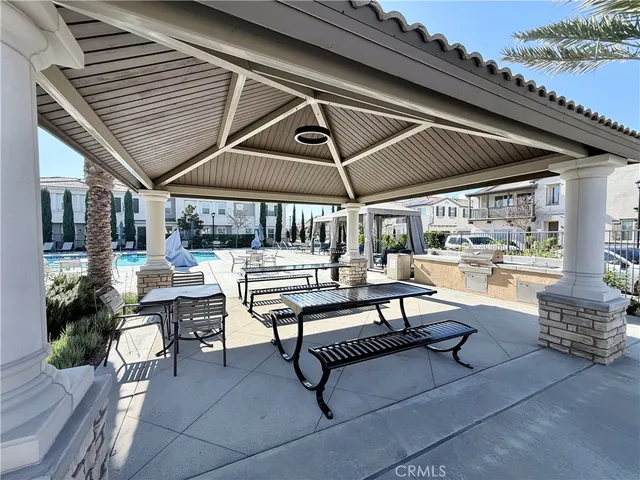 a view of a patio with table and chairs potted plants with wooden floor and fence