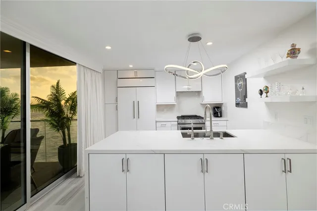a kitchen with a white table chairs and white cabinets