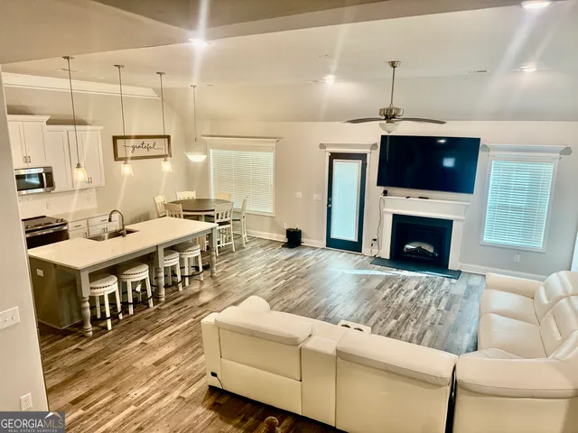 a living room with furniture a flat screen tv and a fireplace