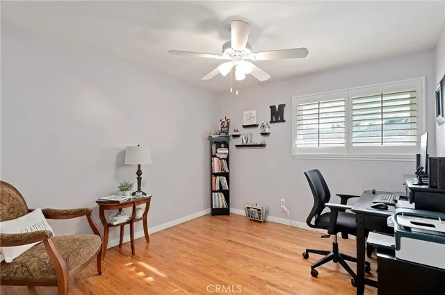 a workspace with chandelier fan and wooden floor