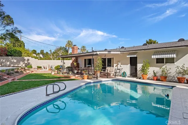 a view of a house with swimming pool and porch with furniture