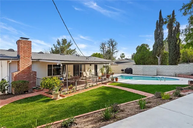 a view of a house with swimming pool and a yard