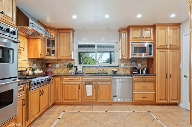 a kitchen with stainless steel appliances granite countertop a stove and cabinets