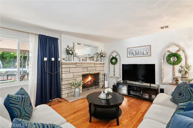 a living room with furniture a fireplace and a flat screen tv