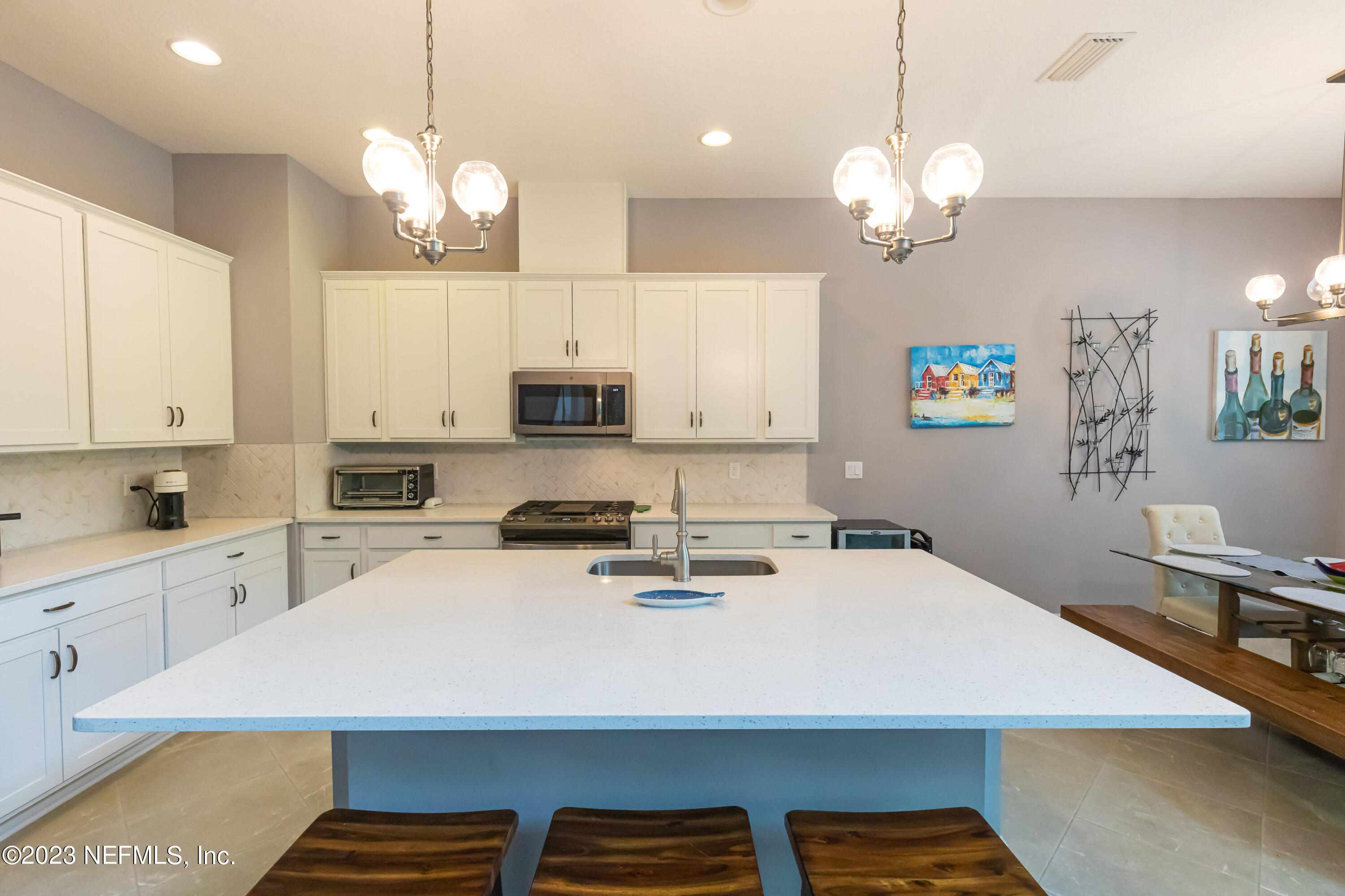 299 Tate Lane St. Johns, FL 32259 - Photo 14 of 55 a kitchen with kitchen island a stove a sink a center island and cabinets