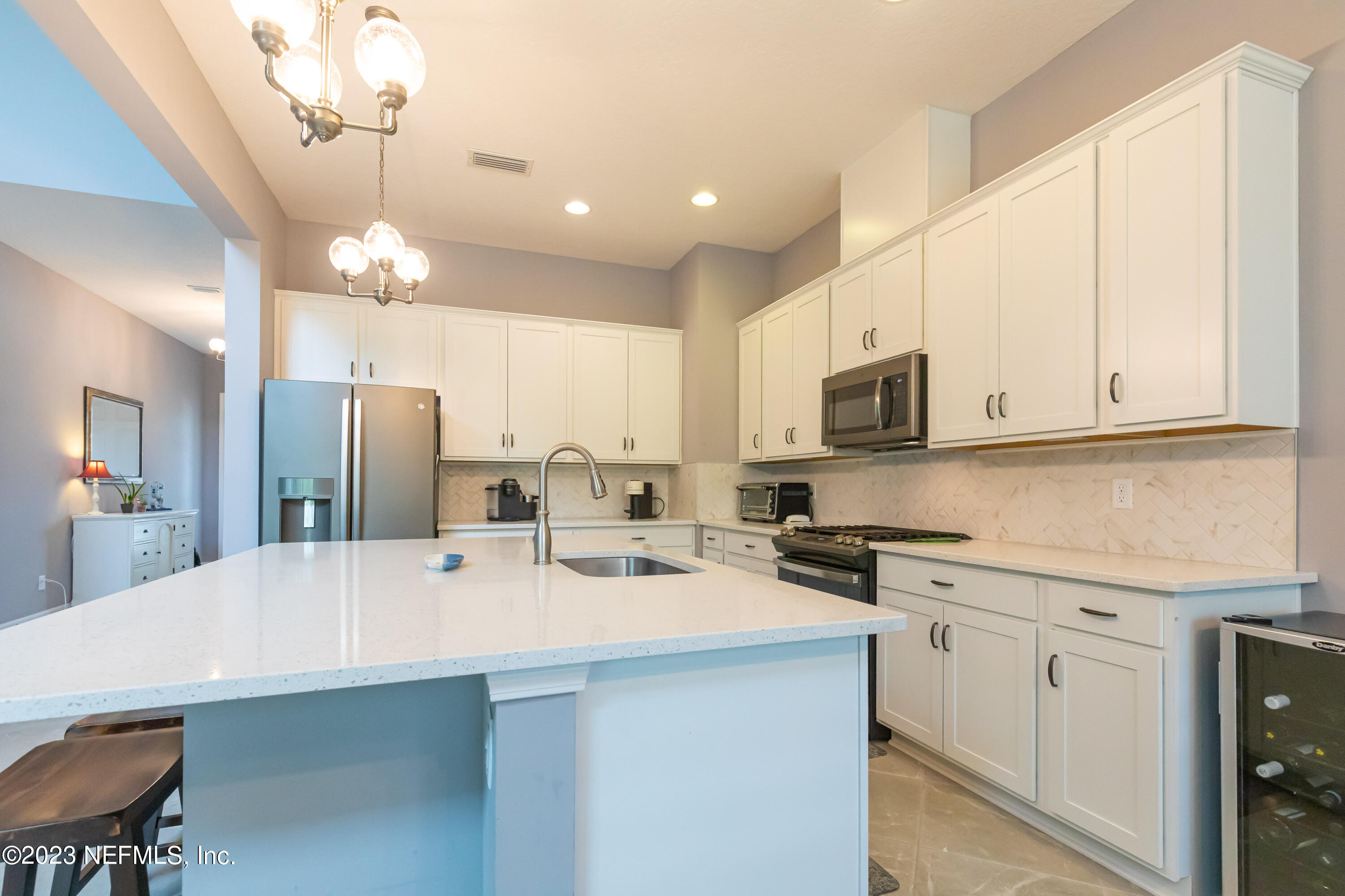 299 Tate Lane St. Johns, FL 32259 - Photo 17 of 55 a kitchen with stainless steel appliances a sink a stove a refrigerator cabinets and a dining table