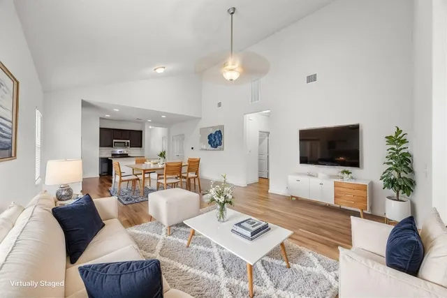 a living room with furniture a flat screen tv and a large window