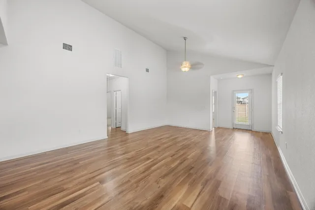 a view of empty room with wooden floor and window