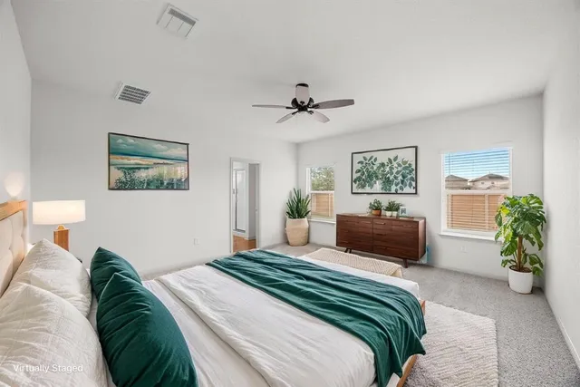 a bedroom with a large bed and a chandelier