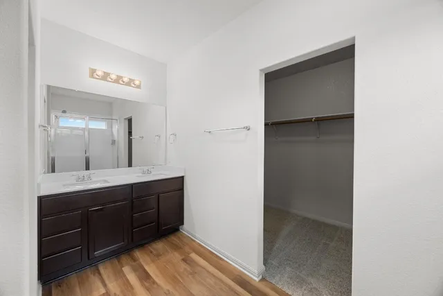 a spacious bathroom with a double vanity sink and mirror