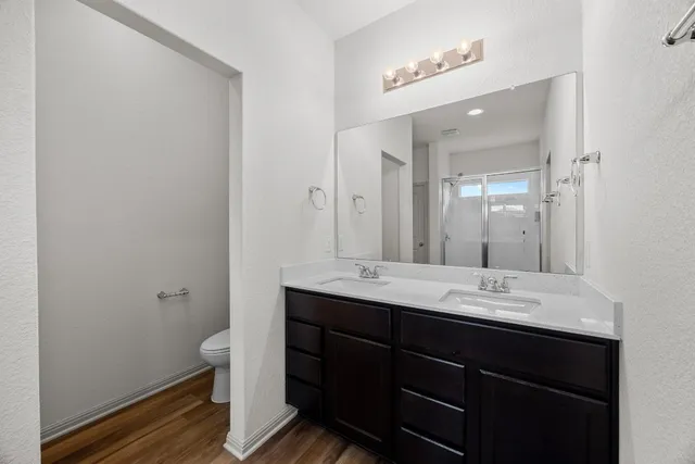 a bathroom with a double vanity sink toilet and mirror