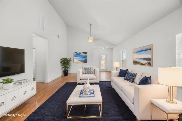 a living room with furniture flat screen tv and white walls