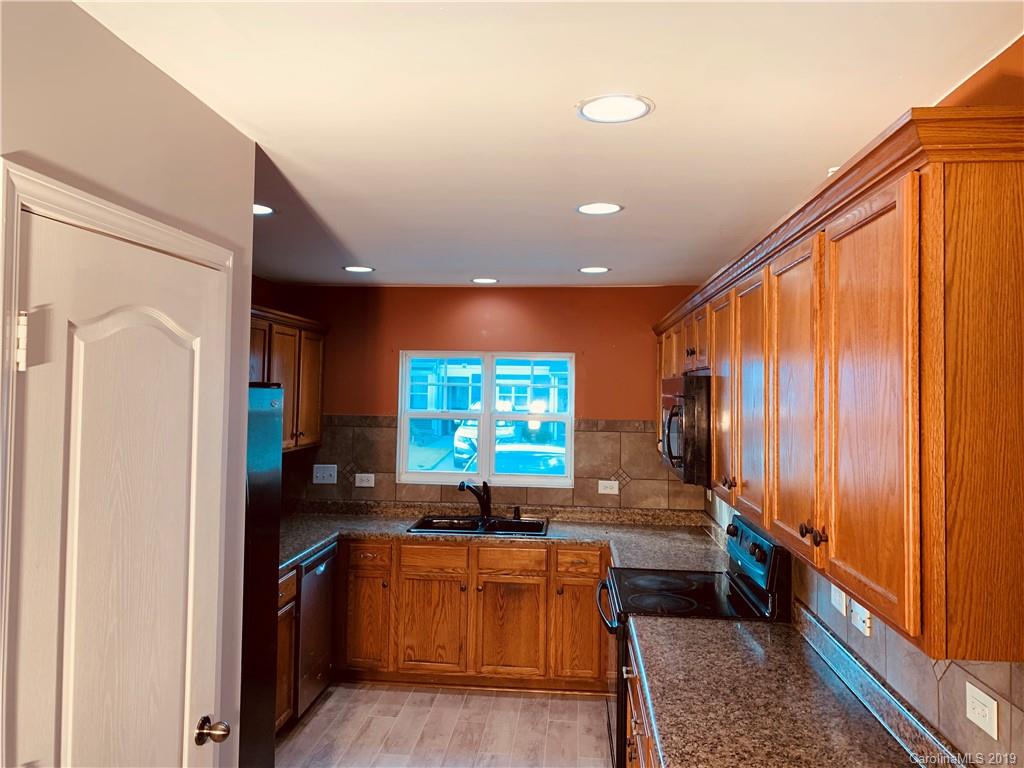 665 Potter Place Road, Unit 105 Fort Mill, SC 29708 - Photo 5 of 14 a kitchen with stainless steel appliances granite countertop a refrigerator and a sink