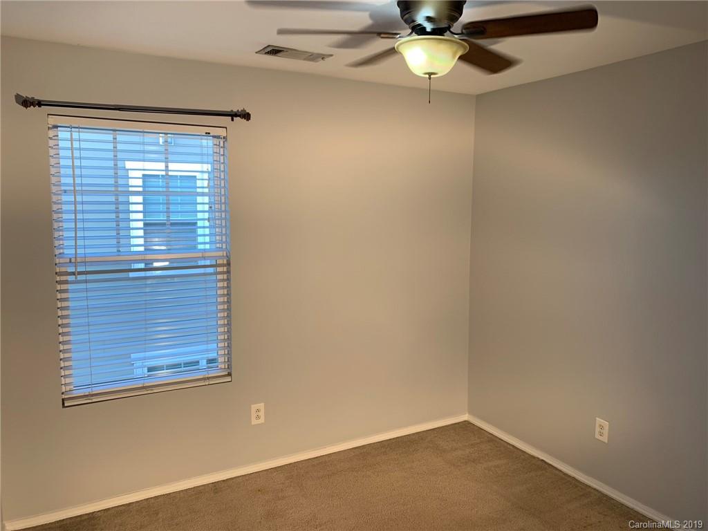 665 Potter Place Road, Unit 105 Fort Mill, SC 29708 - Photo 8 of 14 an empty room with a window and ceiling fan