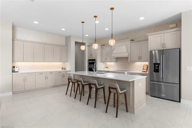 a kitchen with a white center island a sink stainless steel appliances and cabinets