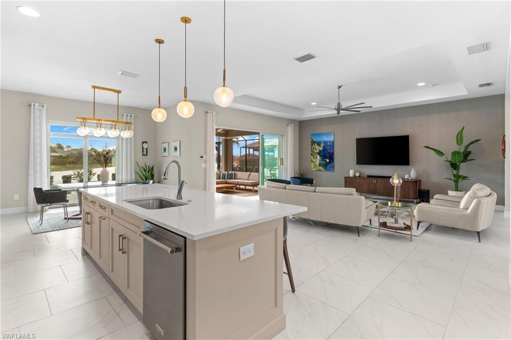 14433 Neptune Avenue Naples, FL 34114 - Photo 22 of 38 a large kitchen with kitchen island a flat screen tv and a view of living room