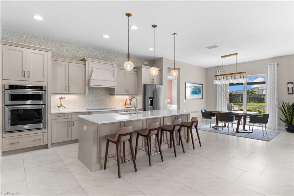 14433 Neptune Avenue Naples, FL 34114 - Photo 23 of 38 a large kitchen with lots of furniture and appliances