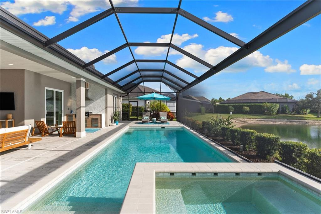 14433 Neptune Avenue Naples, FL 34114 - Photo 26 of 38 a swimming pool with barbeque oven in front of it