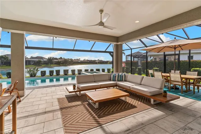 a living room with patio furniture and a large window