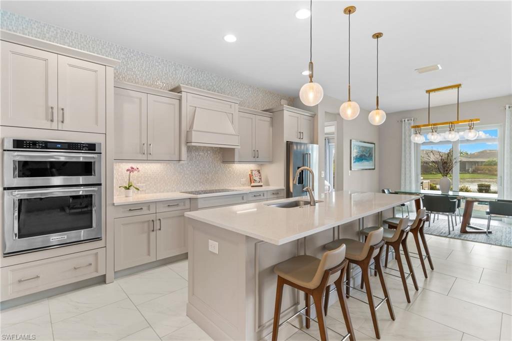 14433 Neptune Avenue Naples, FL 34114 - Photo 7 of 38 a kitchen with cabinets appliances and a dining table