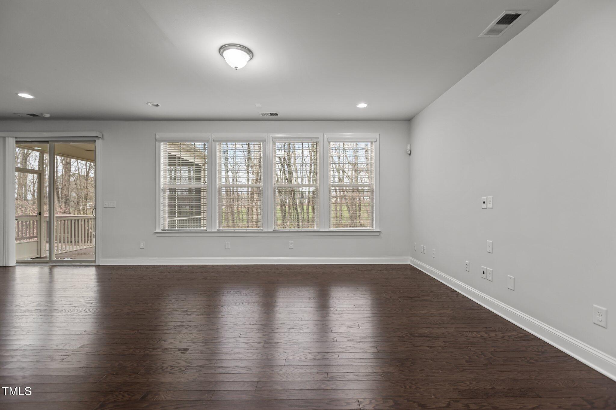 1800 Bodwin Lane Apex, NC 27502 - Photo 11 of 63 an empty room with wooden floor and windows