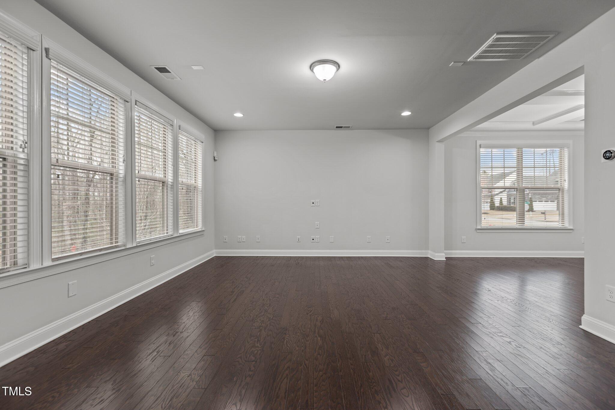 1800 Bodwin Lane Apex, NC 27502 - Photo 12 of 63 an empty room with wooden floor and windows