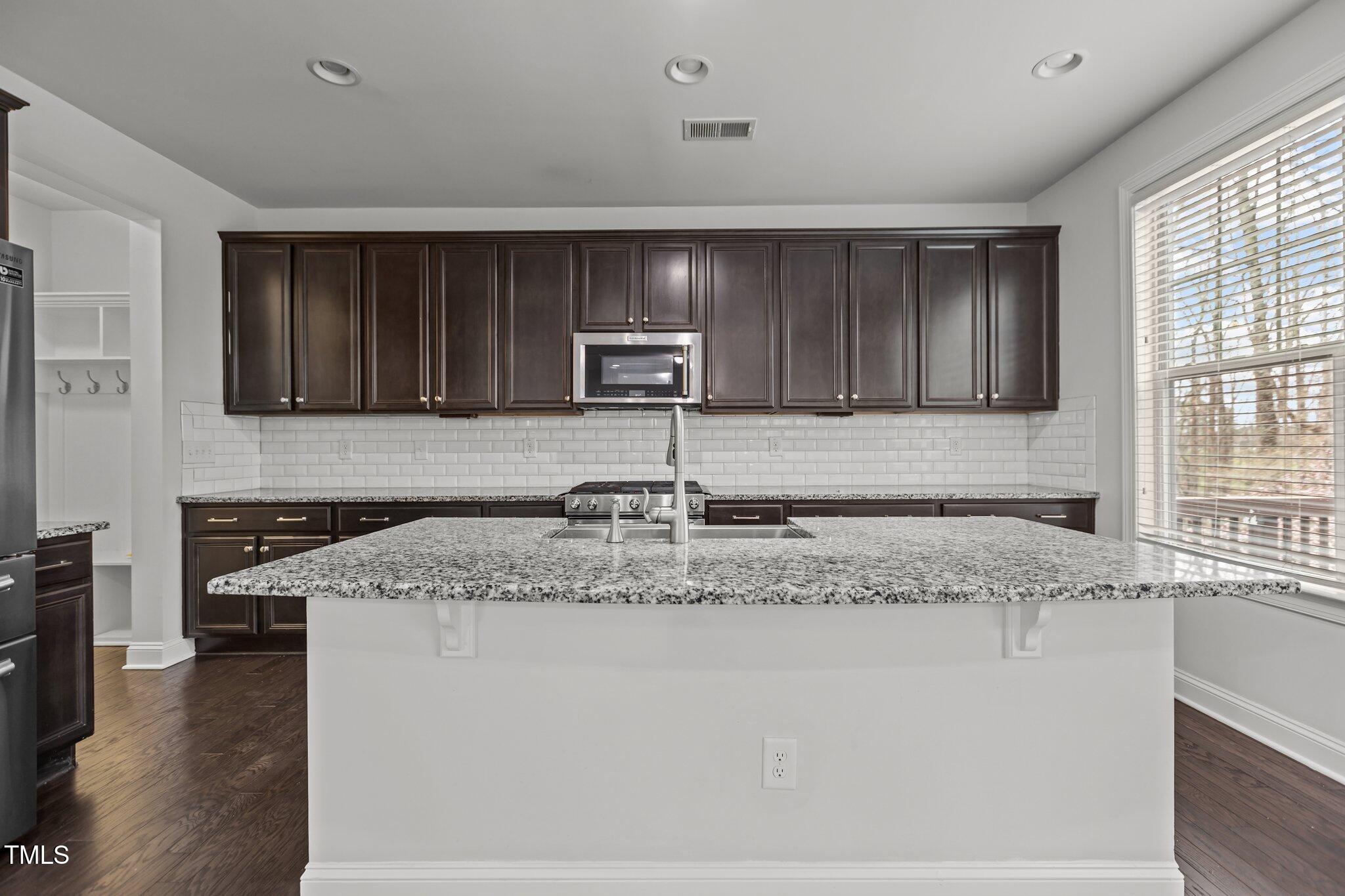 1800 Bodwin Lane Apex, NC 27502 - Photo 17 of 63 a kitchen with granite countertop cabinets sink and stove