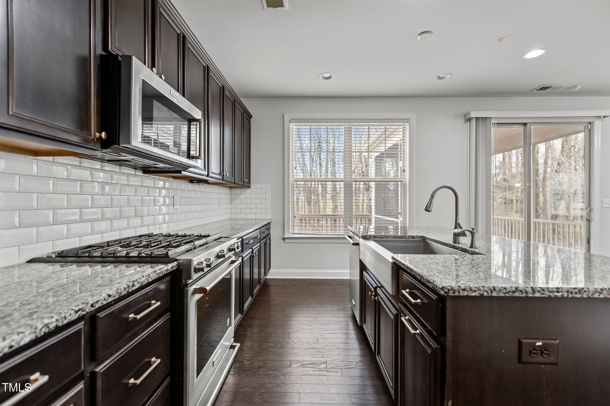 1800 Bodwin Lane Apex, NC 27502 - Photo 18 of 63 a kitchen with granite countertop a sink stove and cabinets