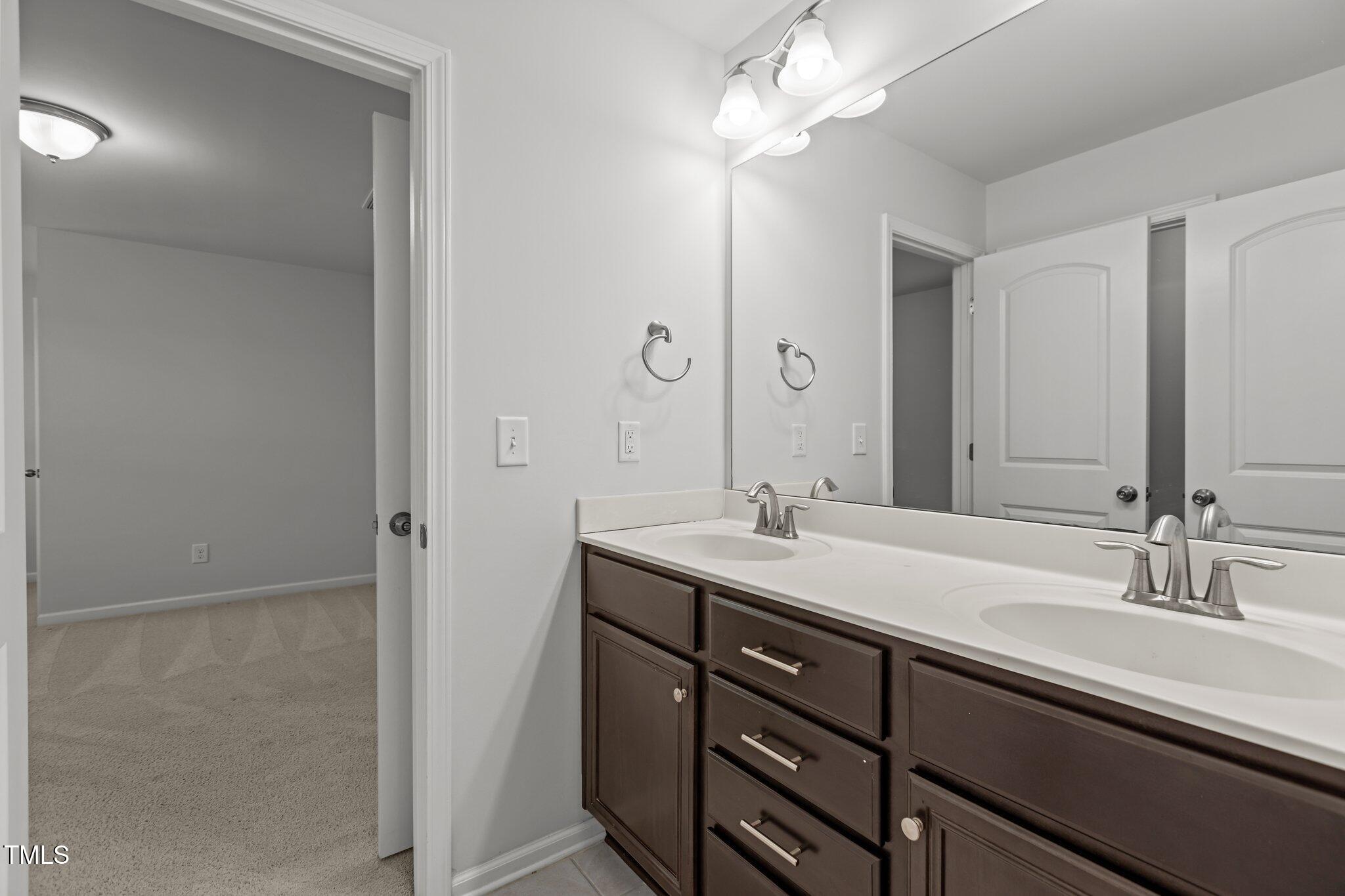 1800 Bodwin Lane Apex, NC 27502 - Photo 32 of 63 a bathroom with a sink a light fixture and a mirror