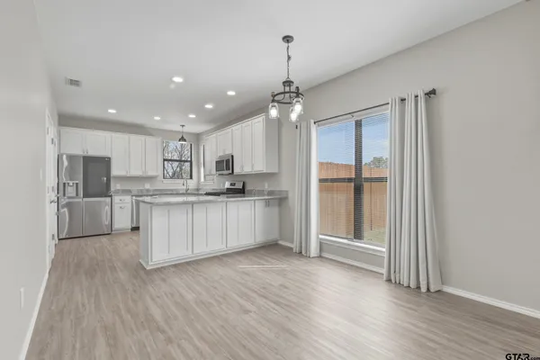 a large kitchen with a lot of counter space and stainless steel appliances