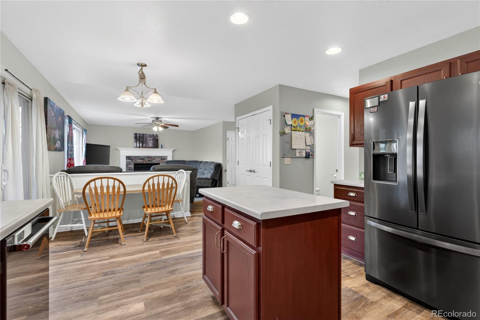 6289 Viewpoint Avenue Firestone, CO 80504 - Photo 12 of 45 a kitchen with stainless steel appliances granite countertop a refrigerator a stove and a dining table with wooden floor