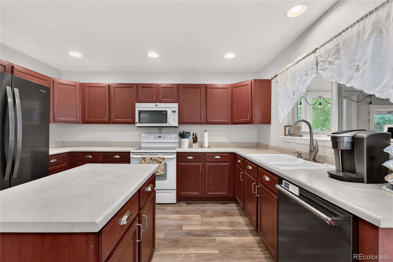 6289 Viewpoint Avenue Firestone, CO 80504 - Photo 13 of 45 a kitchen with a sink a stove top oven and refrigerator