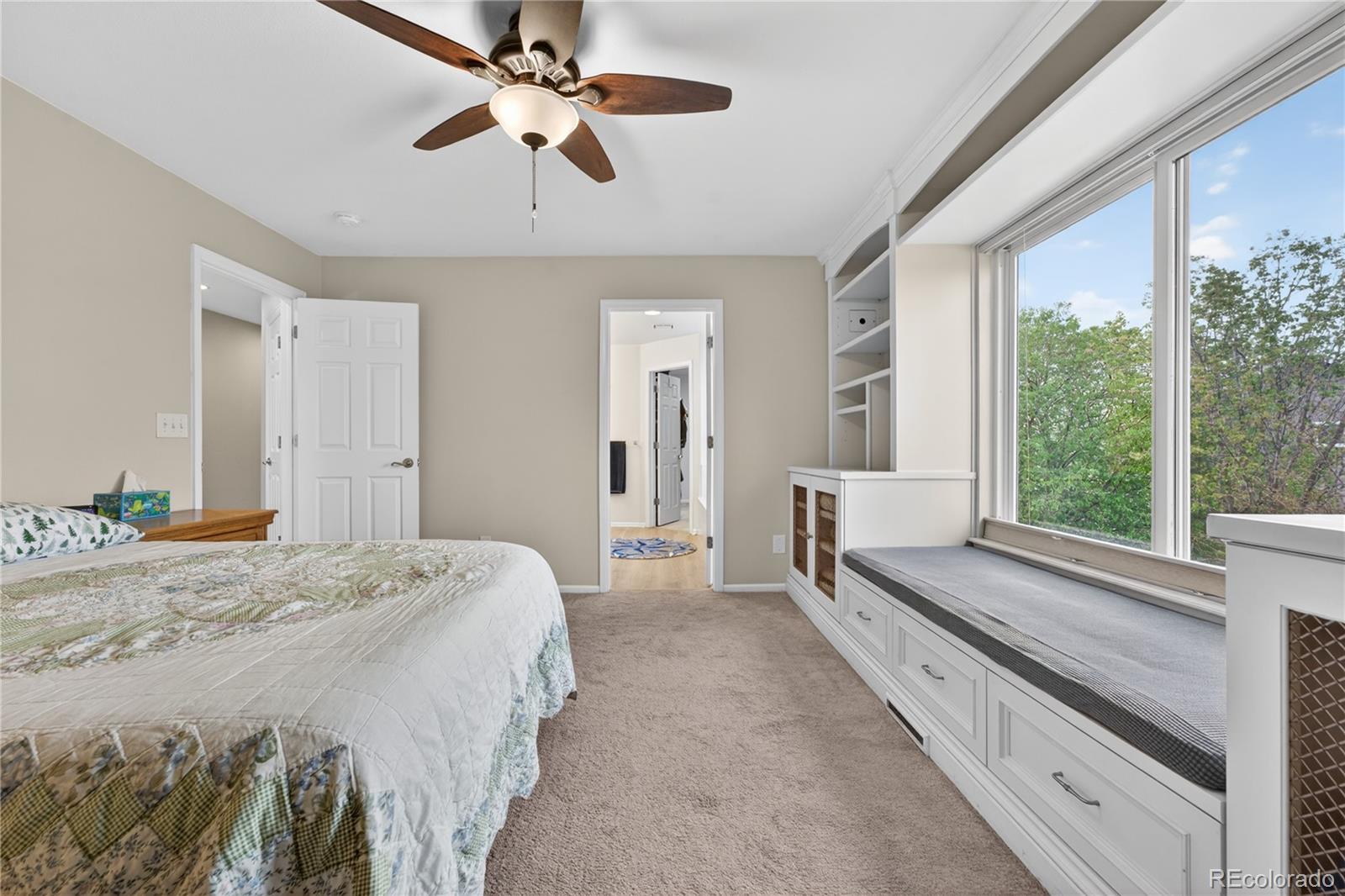 6289 Viewpoint Avenue Firestone, CO 80504 - Photo 22 of 45 a spacious bedroom with a large bed and a chandelier fan