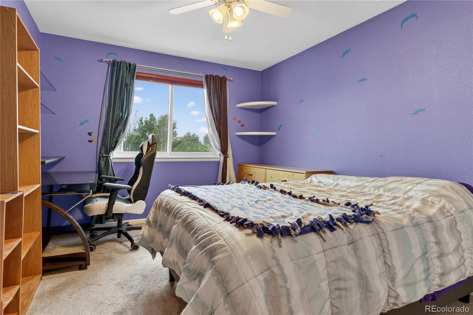 6289 Viewpoint Avenue Firestone, CO 80504 - Photo 28 of 45 a bedroom with a bed and a chandelier