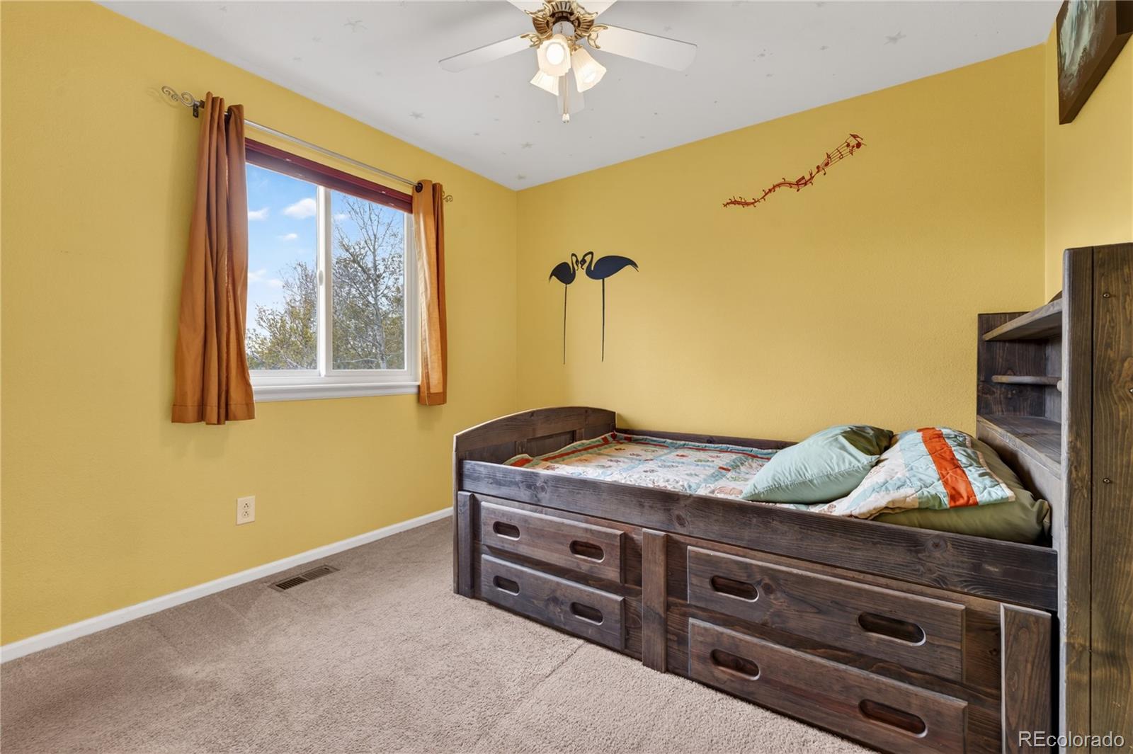 6289 Viewpoint Avenue Firestone, CO 80504 - Photo 29 of 45 a bedroom with a bed and a chandelier
