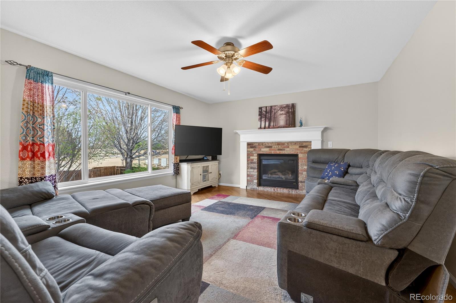 6289 Viewpoint Avenue Firestone, CO 80504 - Photo 6 of 45 a living room with furniture a flat screen tv and a large window
