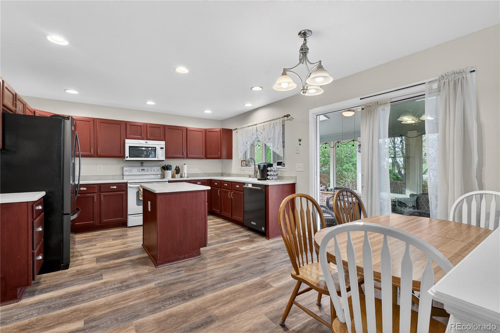 6289 Viewpoint Avenue Firestone, CO 80504 - Photo 8 of 45 a kitchen with stainless steel appliances granite countertop a refrigerator a stove top oven a sink dishwasher a dining table and chairs with wooden floor