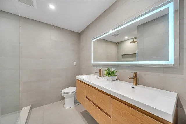 a bathroom with a sink a toilet and mirror