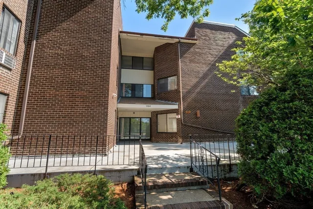 a brick building with a tree in front