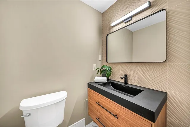 a bathroom with a sink a toilet and mirror