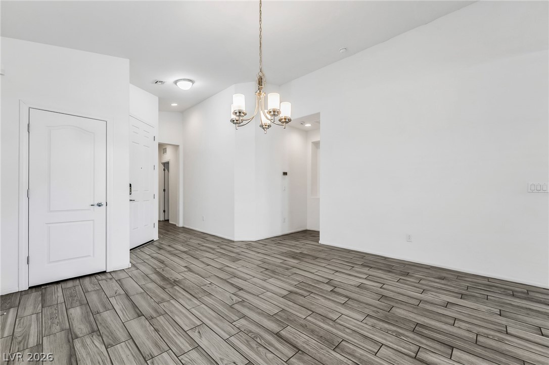 6245 Andover Wood Road Las Vegas, NV 89113 - Photo 7 of 37 Wood-look tile flooring flows seamlessly through this entry, complemented by a chic chandelier.