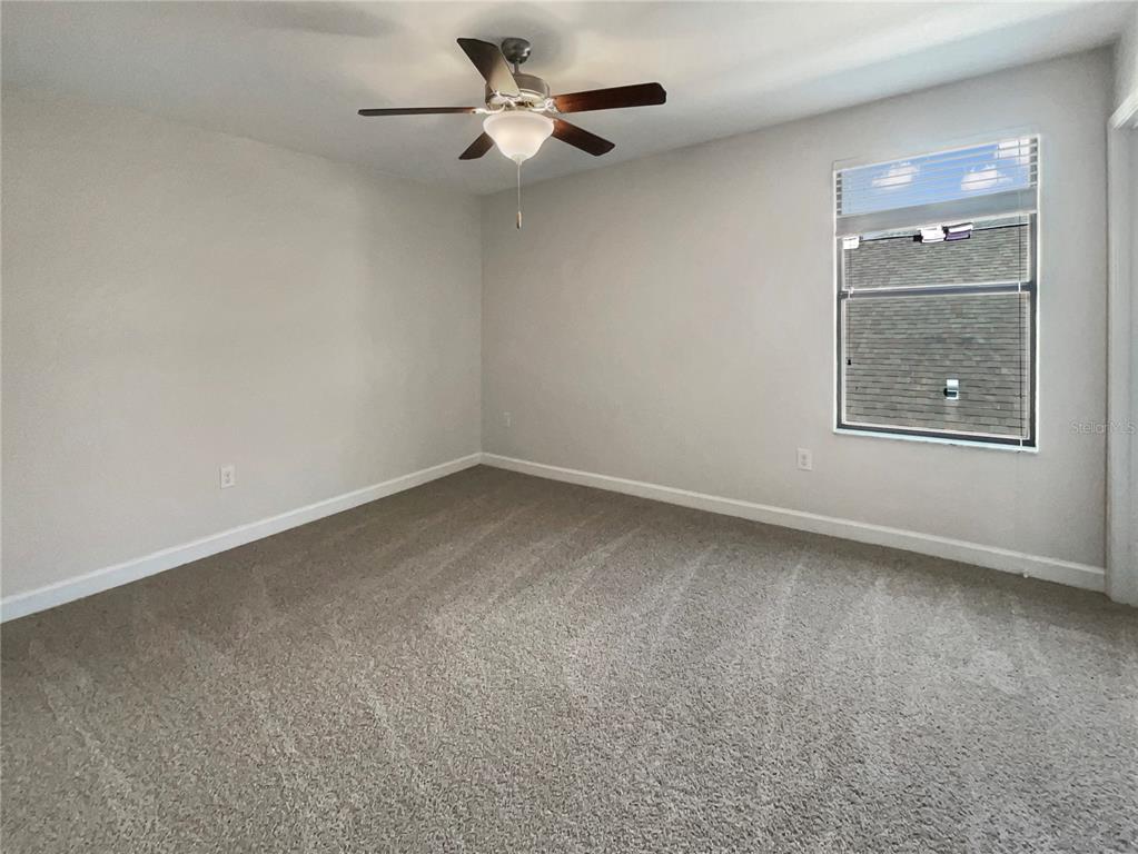 19491 Paddock View Drive Tampa, FL 33647 - Photo 26 of 28 an empty room with a empty space and a ceiling fan