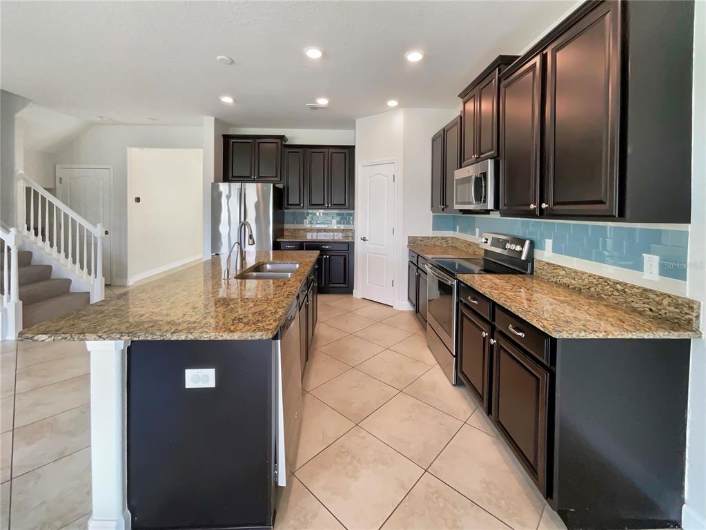 19491 Paddock View Drive Tampa, FL 33647 - Photo 6 of 28 a kitchen with stainless steel appliances granite countertop a sink stove and refrigerator